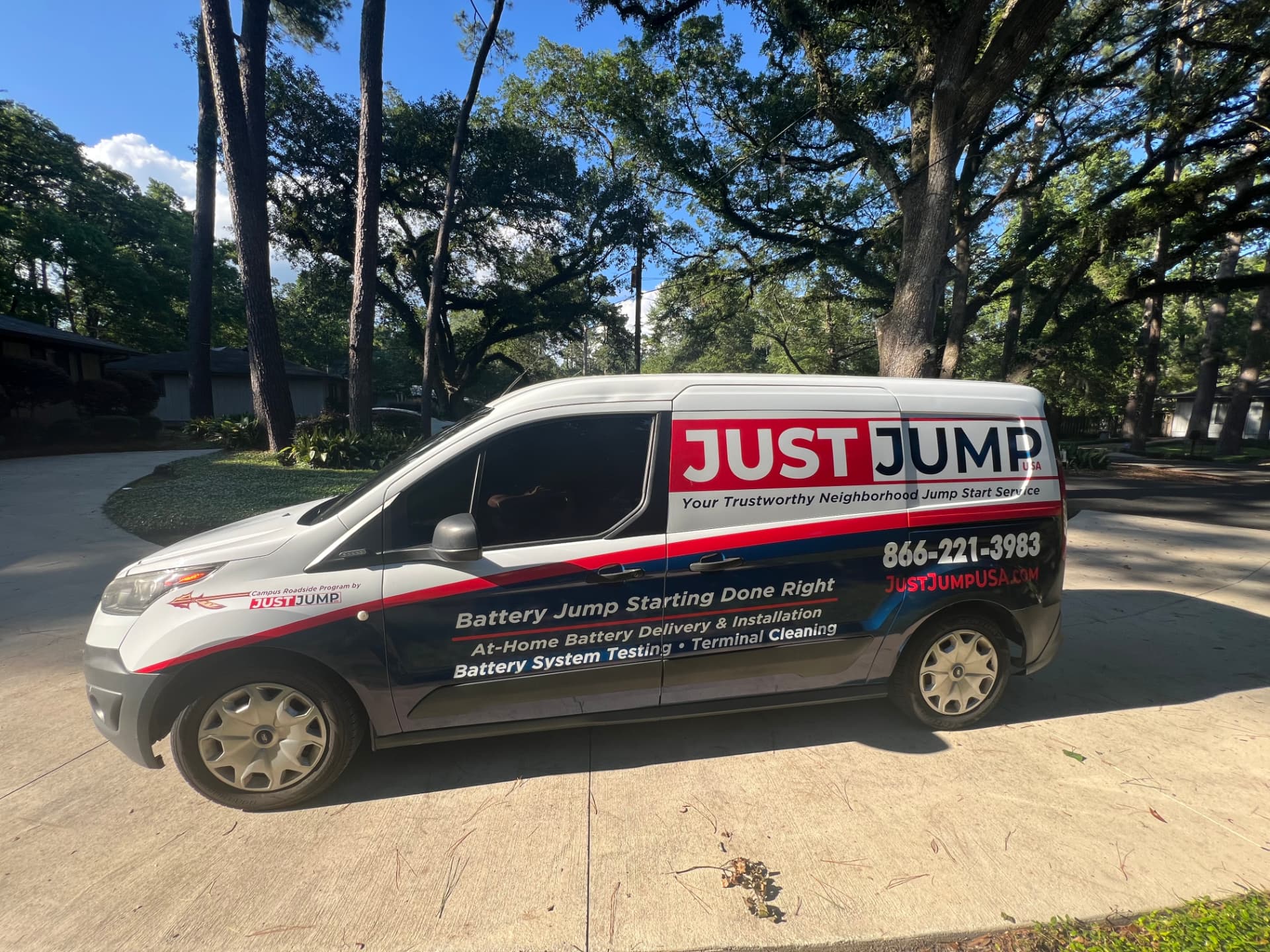 Just Jump USA® service van parked beneath oak trees in a Tallahassee neighborhood